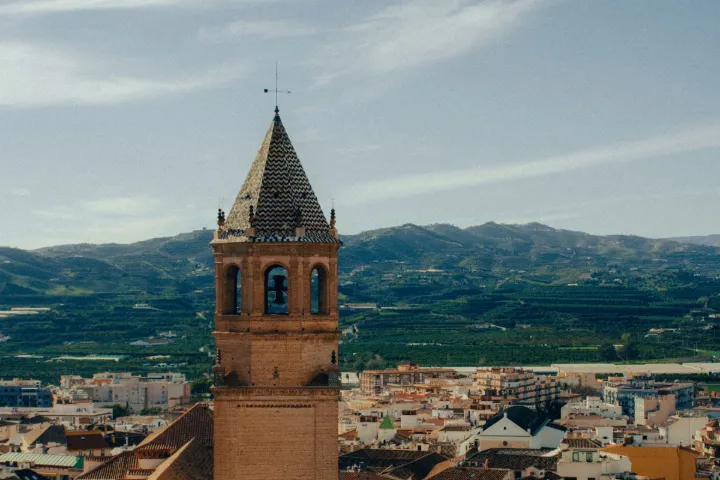 Torre de iglesia y casco urbano de Vélez-Málaga con la sierra al fondo