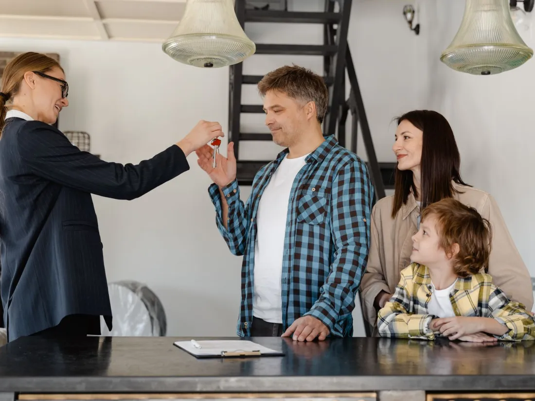 Agente inmobiliaria entregando las llaves de una vivienda