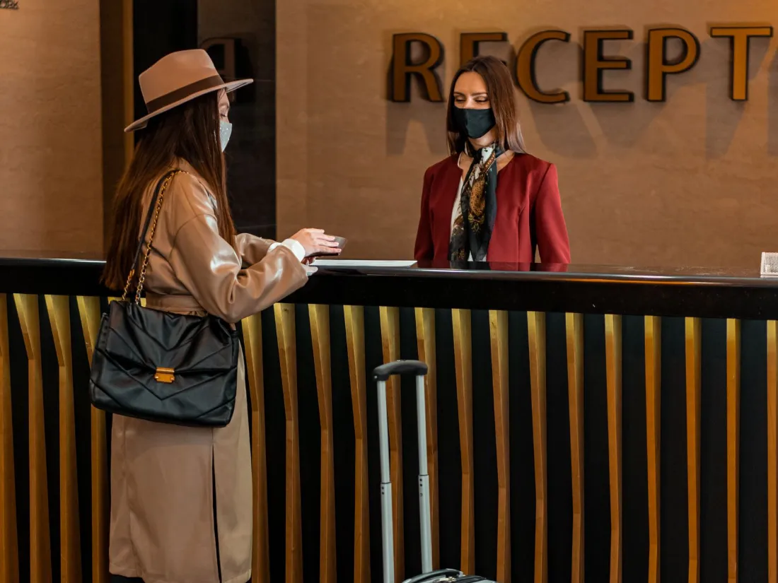 Huésped haciendo el registro en la recepción del hotel