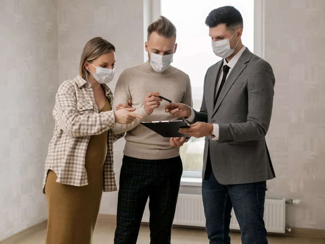 Clientes firmando documentos con un agente inmobiliario