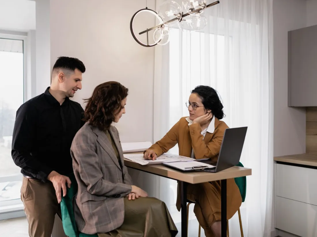 Agente inmobiliario conversando con una pareja