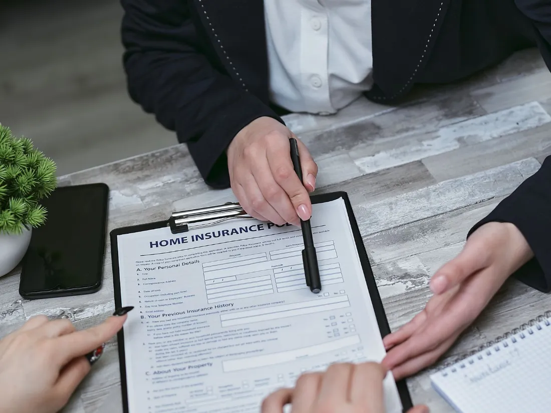 Agente de seguros revisando documentación con clientes