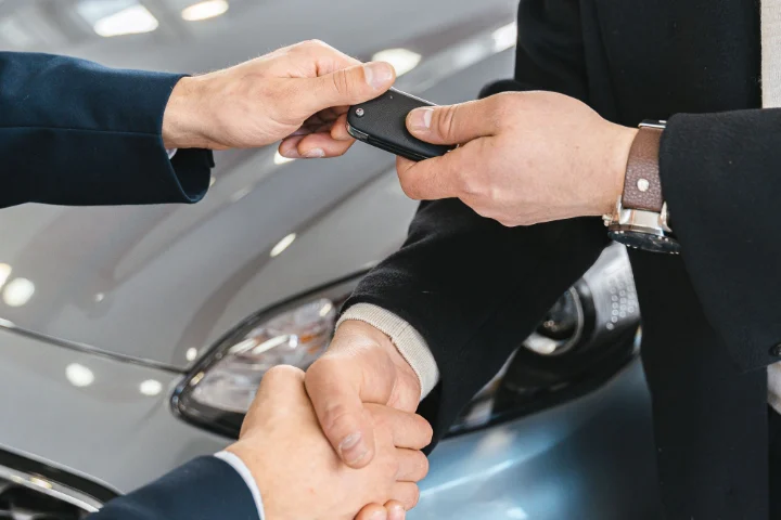 Entrega de llaves de un coche a un cliente en un concesionario