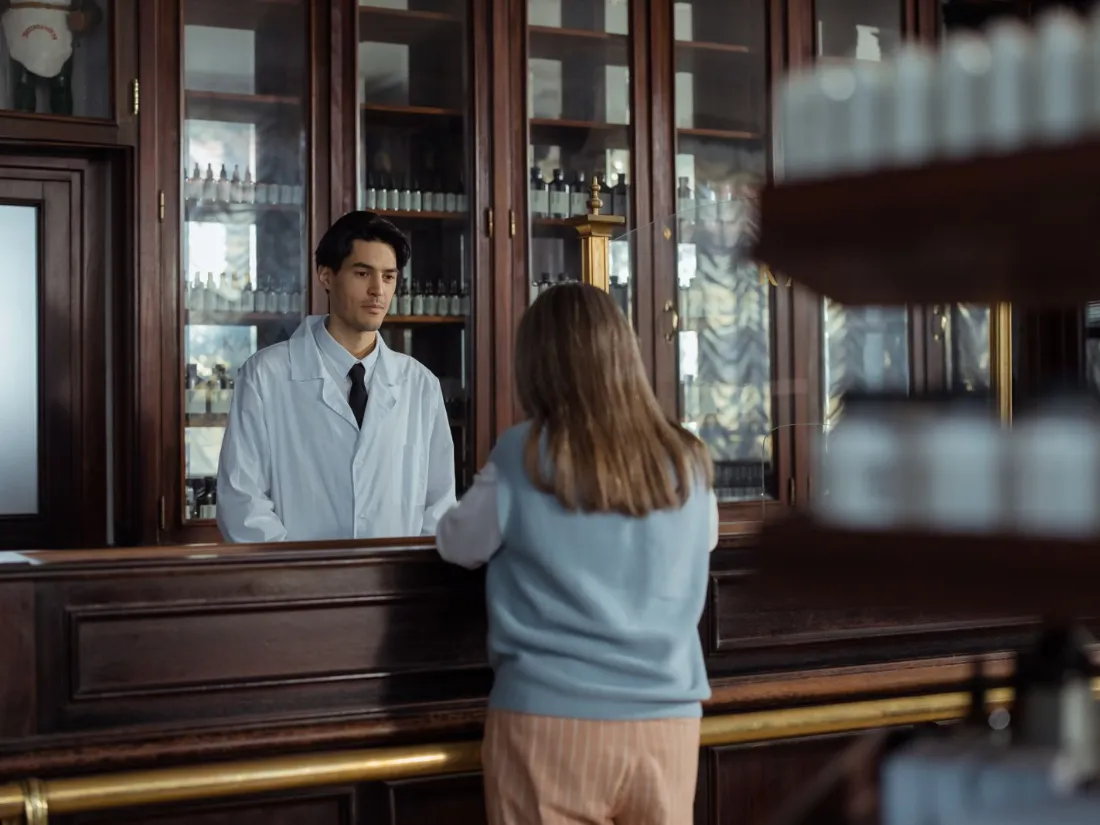 Farmacéutico atendiendo a un cliente en el mostrador