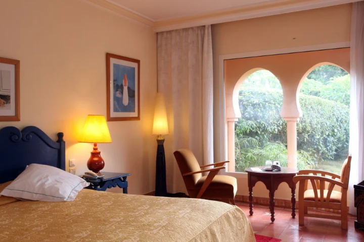 Habitación de hotel con ventanas en arco y vistas al jardín