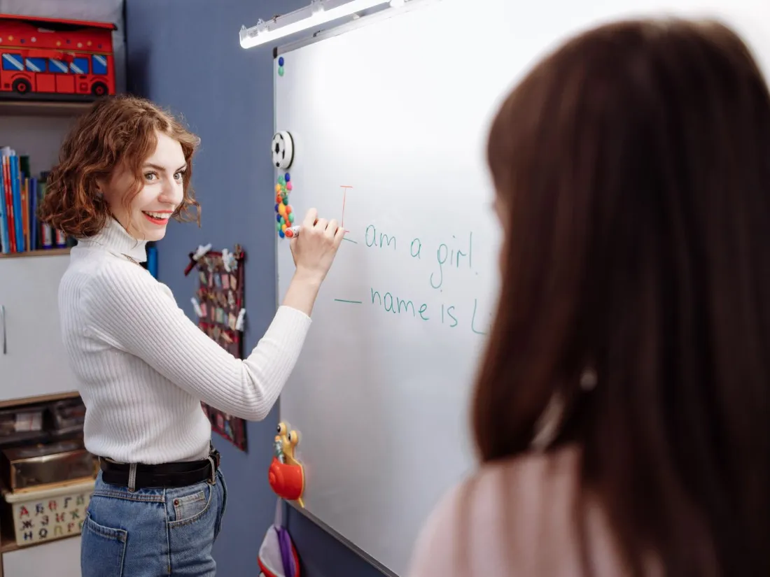 Profesora de inglés escribiendo en la pizarra