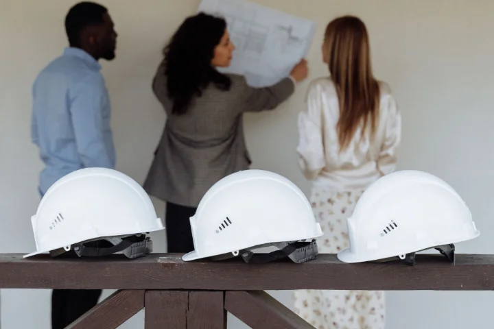 Arquitectos revisando un proyecto en obra con los clientes