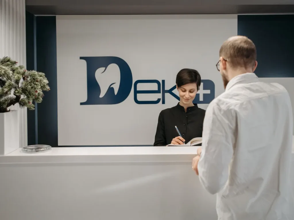 Recepcionista atendiendo a un paciente en una clínica dental