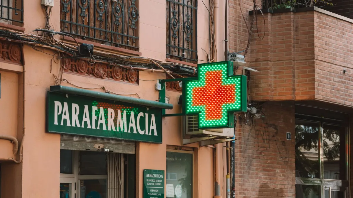 Fachada de una parafarmacia con la cruz verde iluminada