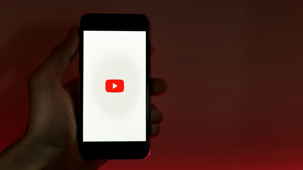 Mano sujetando un móvil con la aplicación de YouTube abierta