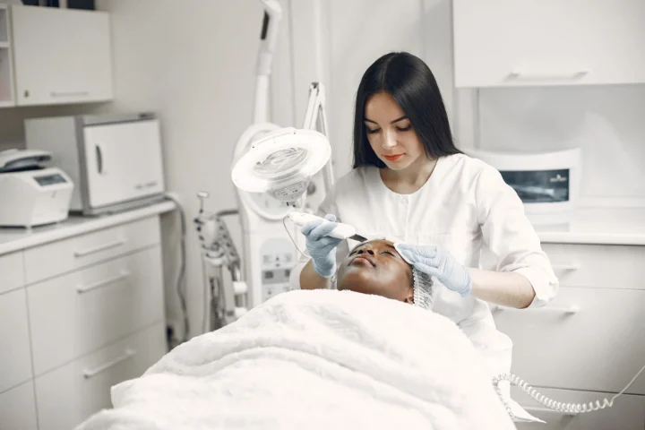 Profesional aplicando un tratamiento facial en la cabina de una clínica
