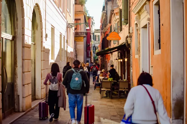 Turistas con maletas paseando por una calle del centro histórico