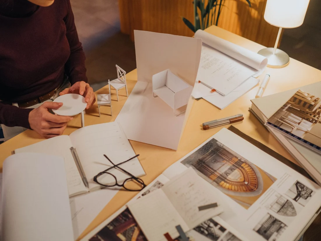 Maqueta y planos sobre la mesa de un estudio de arquitectura