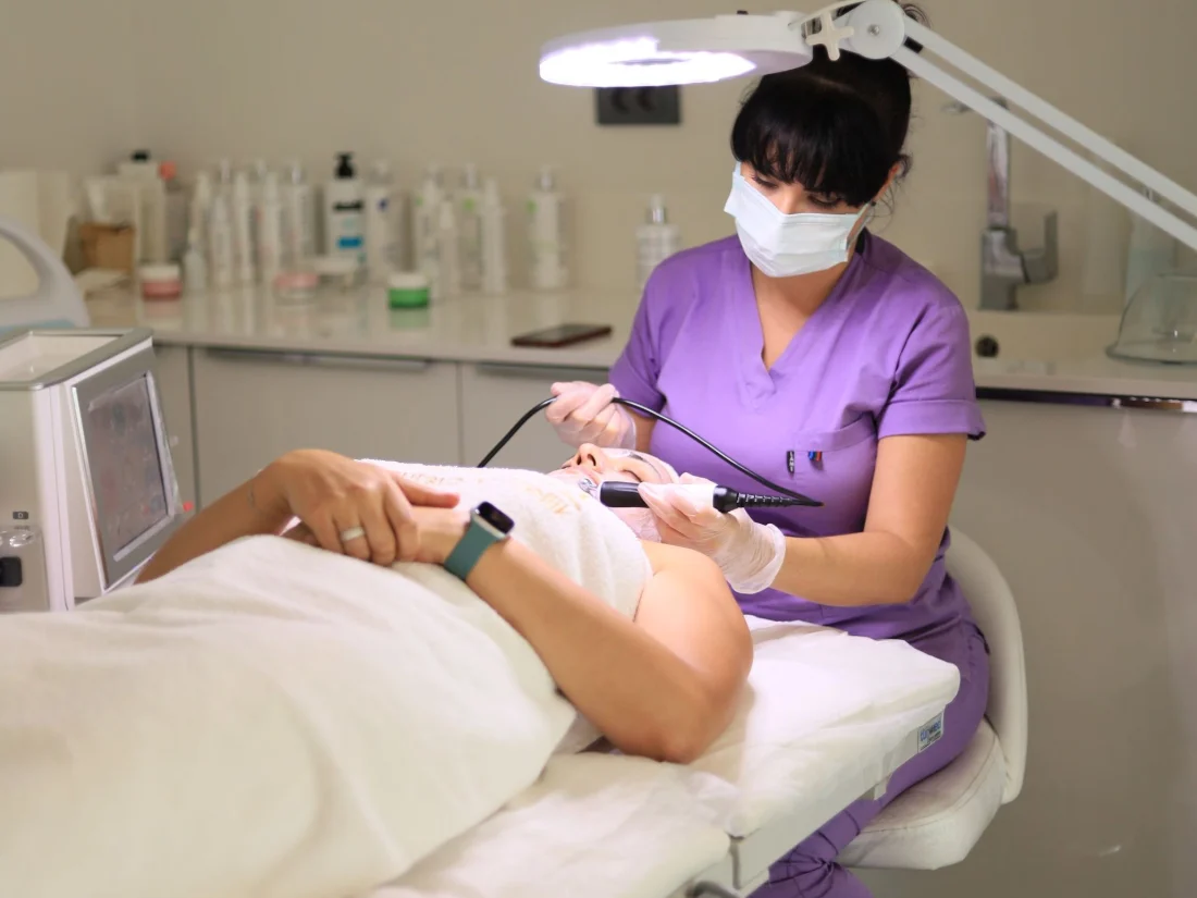 Profesional de estética realizando un tratamiento a una paciente