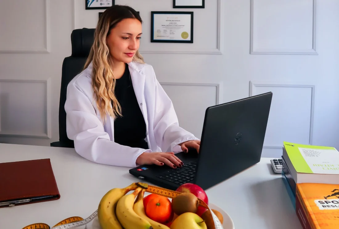 Nutricionista trabajando con el portátil en su consulta